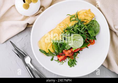 Omelette avec roquette, tomates et basilic dans une assiette Banque D'Images
