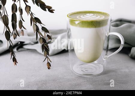 Verre de latte de thé vert matcha chaud avec motif tulipe Banque D'Images