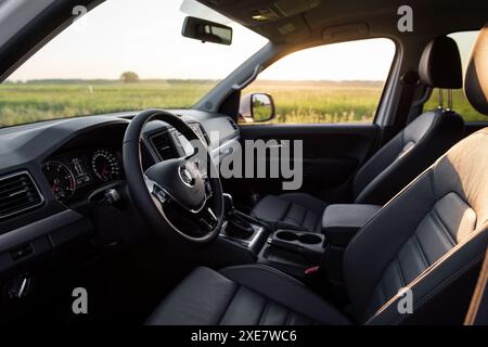 Intérieur de Volkswagen Amarok. Rangée avant des sièges et tableau de bord de la camionnette VW dans un champ. Banque D'Images