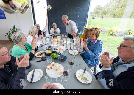 Joyeux aîné se réunissant autour de la table à manger Banque D'Images