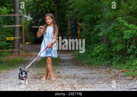 Un enfant abandonné sans-abri affamé cherche de la nourriture et un abri avec son petit chien Banque D'Images