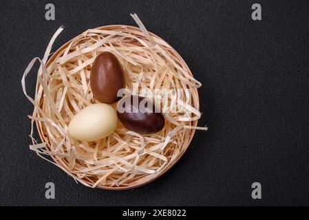 Poule de Pâques en chocolat et oeufs dans un nid avec de la paille Banque D'Images