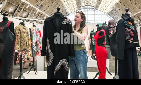 Londres, Royaume-Uni. 26 juin 2024. Isabella Rabasse de la Royal School of Needlework apporte la touche finale à son présentoir design. Les diplômés montrent leurs créations au New designers Design Graduate Show au Business Design Centre. L'événement se déroule sur deux semaines, mettant en lumière de nouveaux talents dans la mode, textiles, meubles, design de produits, illustration, et bien plus encore. Crédit : Imageplotter/Alamy Live News Banque D'Images
