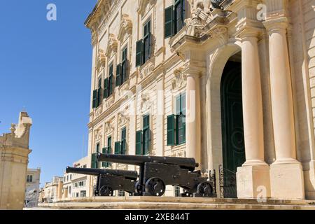 Valletta, Malte - 3 août 2023 : vieux canons devant l'entrée du bâtiment historique de l'Auberge de Castille, qui a servi d'auberge in ou. Banque D'Images