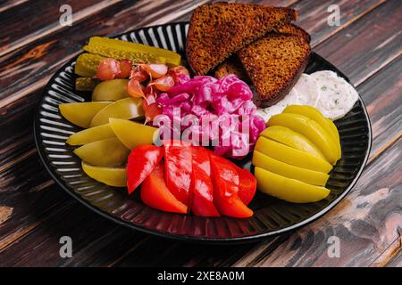 Cornichons, chou, poivrons, pain et ail tartinés sur une assiette Banque D'Images