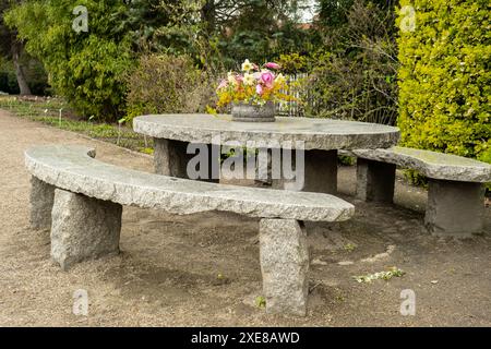 Grande table ronde en pierre sur belle terrasse, patio jardin. Endroit vide pour se détendre en plein air dans la cour arrière. Fleurs en pot vintage. Co Banque D'Images