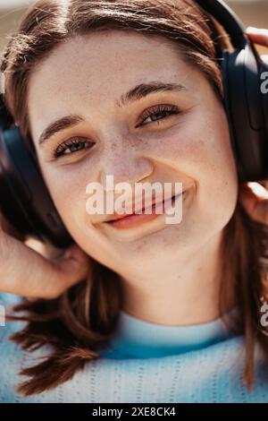 Gros plan d'une jeune femme qui profite de la musique dans un casque Banque D'Images