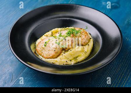 Purée de pommes de terre avec escalopes de viande sur plaque noire Banque D'Images