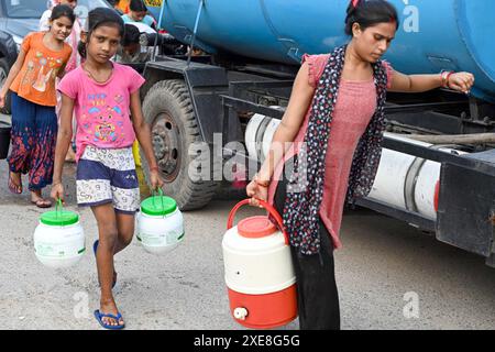 New Delhi, Inde. 25 juin 2024. NEW DELHI, INDE - JUIN 25 : des gens remplissent l'eau d'un ravitaillement en eau du gouvernement de Delhi, pendant une vague de chaleur à haute température, dans la région de New Ashok Nagar le 25 juin 2024 à New Delhi, Inde. (Photo de Sanjeev Verma/Hindustan Times/Sipa USA) crédit : Sipa USA/Alamy Live News Banque D'Images