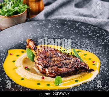 Cuisse de canard rôtie avec une purée de légumes verts Banque D'Images