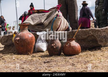 pot en céramique de chicha de jora traditionnelle et verres en bois dans un rituel traditionnel par une journée ensoleillée Banque D'Images