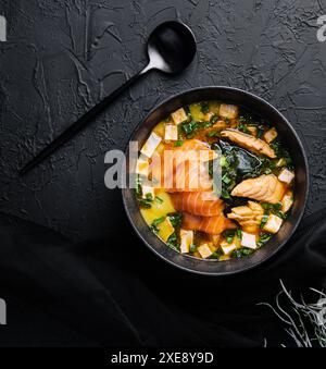 Appétissante soupe miso ishikari avec saumon dans un bol noir Banque D'Images