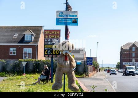 Hartlepool, Cleveland, Royaume-Uni. 26 juin 2024. La circonscription de Hartlepool, où les candidats aux élections générales britanniques de 2024 comprennent Jill Mortimer (Con) et Jonathan Brash (Lab). Lors des élections locales de mai dans la ville, le parti travailliste a remporté les 8 sièges du conseil, soit Con (6) et Ind (2). Sur la photo : une exposition d'un ours en peluche et d'un bilboard électoral conservateur dans un lave-auto. Crédit : Hazel Plater/Alamy Live News Banque D'Images