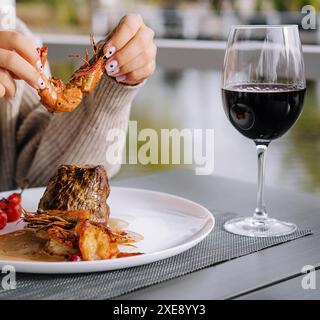 Filet mignon aux crevettes et verre de vin Banque D'Images