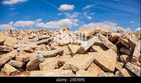 Déversement de piles de débris de béton sur le sol dans la nature de la zone de vignobles avec ciel nuageux. gros pieu Banque D'Images