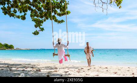 Un couple d'hommes et de femmes à une balançoire sur la plage de Koh Samet île Rayong Thaïlande Banque D'Images