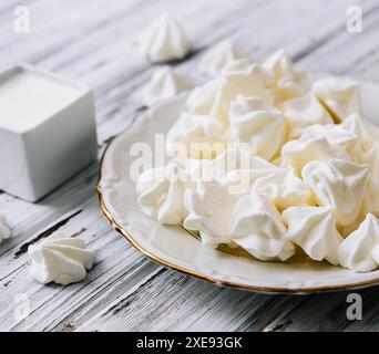 Biscuits meringue dans une assiette sur bois Banque D'Images