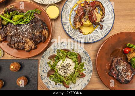 Image vue de dessus de différentes assiettes de différentes coupes de bœuf grillé avec une salade burrata et une assiette avec poulpe Banque D'Images