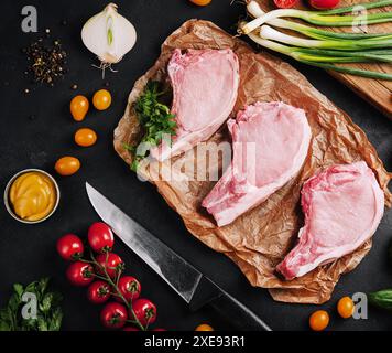 Plusieurs steaks de porc crus sur du papier cuisson Banque D'Images