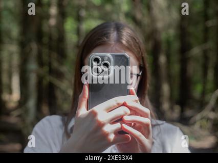 . Lodz Pologne 1 juin 2024 personne prenant des photos avec un téléphone portable, tenant un smartphone, cachant le visage avec un téléphone portable tout en capturant, photographiant dans la nature. P Banque D'Images