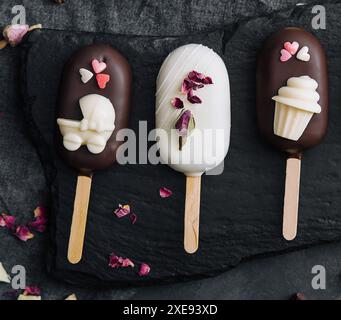 Vue de dessus des crèmes glacées Cake POPS décorées sur fond noir Banque D'Images