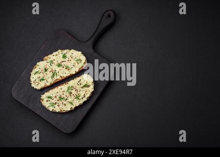 Pain grillé avec pâte d'avocat, œufs, fromage à la crème, sel, épices et herbes Banque D'Images