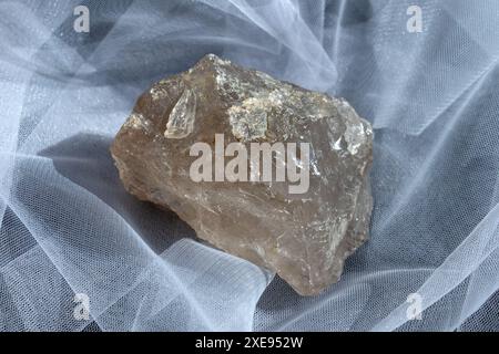 macro photographie de minéral naturel de la collection géologique pierre de cristal de roche de quartz clair brut sur fond de tissu blanc Banque D'Images