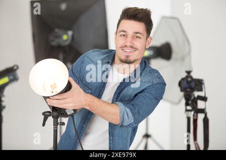 le photographe règle le flash sur le studio Banque D'Images