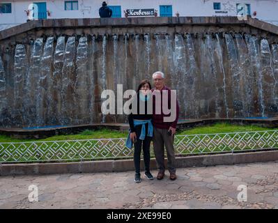 Cusco, Pérou - 9 août 2023 : femme aux cheveux noirs posant avec son père devant une fontaine à Barrio de San Blas Banque D'Images