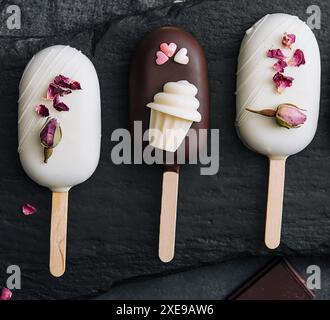 Vue de dessus des crèmes glacées Cake POPS décorées sur fond noir Banque D'Images