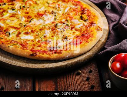 Délicieuse pizza avec des fruits de mer sur un stand en bois Banque D'Images