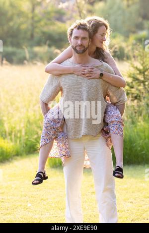 Couple romantique appréciant Piggyback Ride dans la nature Banque D'Images