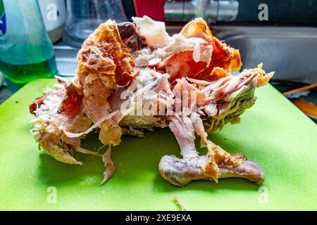 Restes de carcasse d'un poulet rôti, dépouillé de viande laissant juste la peau et les os gaspillés Banque D'Images