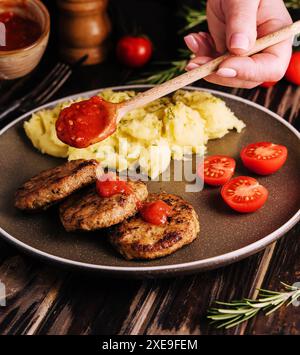 Grand-mère a cuit des côtelettes avec de la purée de pommes de terre Banque D'Images