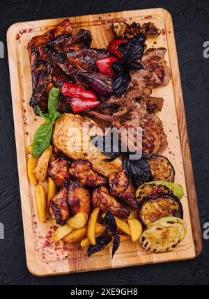 Plat de viande mélangé. côtes grillées, ailes de poulet, carré d'agneau avec légumes Banque D'Images