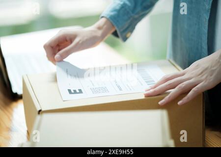 Fixation de l'étiquette d'expédition à un colis Banque D'Images