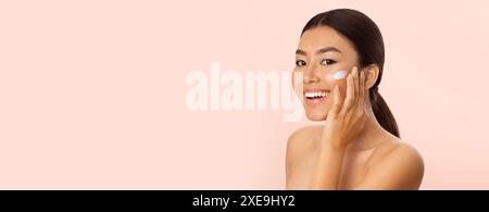 Concept de beauté. Asian Woman Applying Moisturizer On Face Banque D'Images