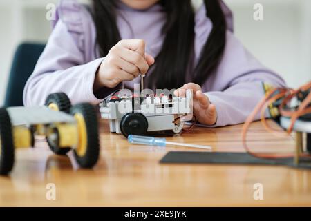 Concept d'éducation STEM. Jeune fille asiatique apprenant la conception de robot. Banque D'Images