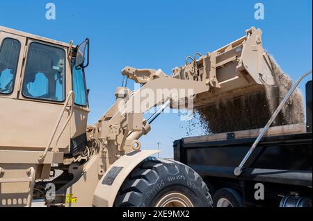 Amn. De l'US Air Force Legre Gnahoua, un opérateur d’équipement lourd et de chaussées du 514e Escadron du génie civil, 514e Escadron de mobilité aérienne, remplit un camion à benne basculante de 10 tonnes de gravier à l’aide d’un chargeur frontal à la base aérienne de Morón, Espagne, le 24 juin 2024. À l'appui du programme de l'Initiative européenne de dissuasion, le 514e ces a soutenu de multiples projets de construction et d'aérodrome sur la base. Avec les conflits en cours en Ukraine, en Israël et dans toute l’Afrique, et la capacité de la base à organiser des avions, de l’équipement et des troupes, les améliorations apportées à la base renforcent notre posture mondiale. Banque D'Images