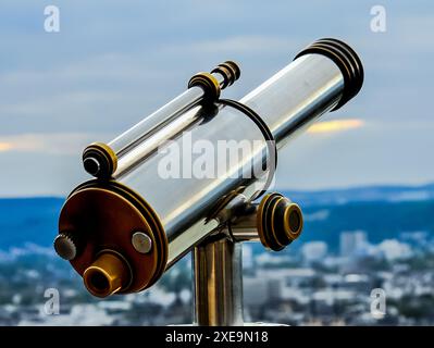 Jumelles d'inspection au sommet d'un gratte-ciel pour observer la ville. Banque D'Images