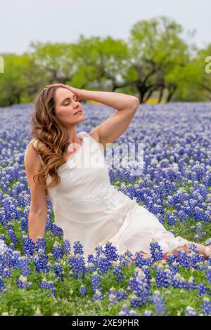 Un beau modèle Brunette pose dans Un champ de fleurs de Bluebonnet dans Un Prarie Texas Banque D'Images