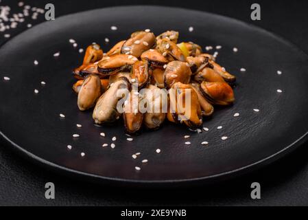 Délicieuses moules marinées aux épices et aux herbes sur une assiette en céramique Banque D'Images