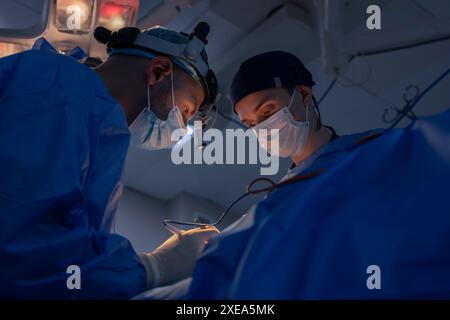 Les chirurgiens masculins effectuent la chirurgie dans la salle d'opération, chirurgien plastique dans la salle d'opération, Une équipe chirurgicale effectue une opération Banque D'Images