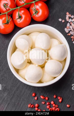 Délicieux fromage mozzarella frais sous forme de petites boules avec du sel et des épices Banque D'Images