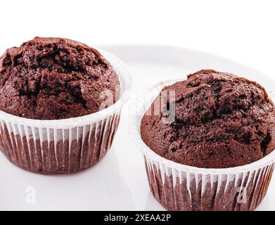 Cupcakes au chocolat sur une assiette isolée sur blanc Banque D'Images