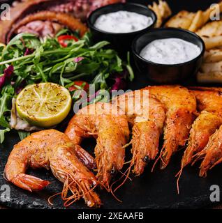 Fruits de mer grecs traditionnels grillés sur une assiette en bois du restaurant Banque D'Images