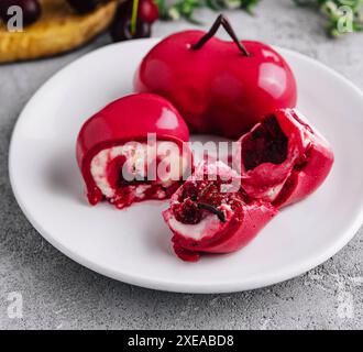 Gâteau mousse avec glaçage miroir et remplissage cerise Banque D'Images