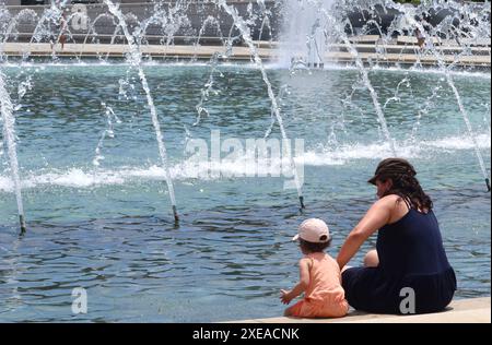 Washington, États-Unis. 26 juin 2024. Les gens se rafraîchissent à une fontaine à Washington, DC, aux États-Unis, le 26 juin 2024. Washington, DC a connu une vague de chaleur mercredi, avec des températures grimpant à 36,7 degrés Celsius. Crédit : Liu Shuxian/Xinhua/Alamy Live News Banque D'Images