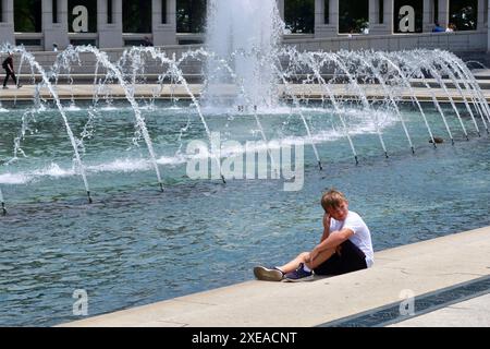 Washington, États-Unis. 26 juin 2024. Un enfant se rafraîchit à une fontaine à Washington, DC, aux États-Unis, le 26 juin 2024. Washington, DC a connu une vague de chaleur mercredi, avec des températures grimpant à 36,7 degrés Celsius. Crédit : Liu Shuxian/Xinhua/Alamy Live News Banque D'Images