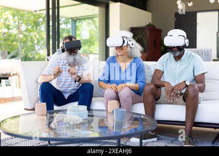 À la maison, groupe diversifié d'amis utilisant des casques VR, profitant de l'expérience de réalité virtuelle Banque D'Images